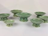 a group of small green dishes on a white table