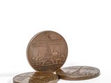 three coins sitting on top of each other on a white surface