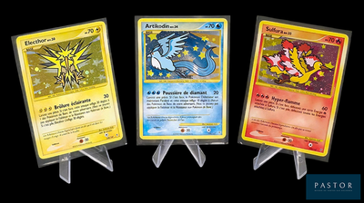 Trois cartes Pokémon sont représentées en rangée sur un fond noir