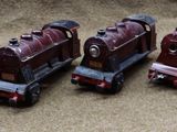 several toy trains are lined up in a row on the floor