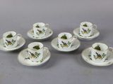 six cups and saucers with flowers on them sitting on a table