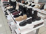 de nombreuses paires de chaussures posées sur une table dans un magasin de chaussures