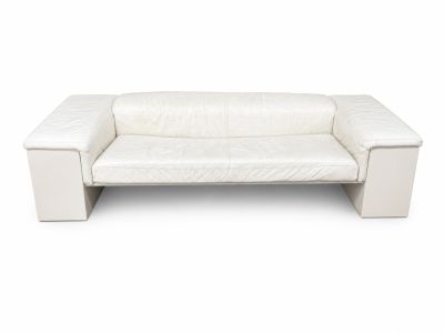 Le canapé en cuir blanc est posé sur une surface blanche.
