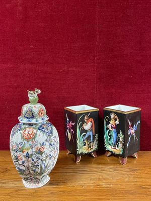 trois vases posés sur une table près d'un mur rouge
