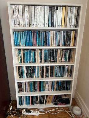 a book shelf with many books on it in a room