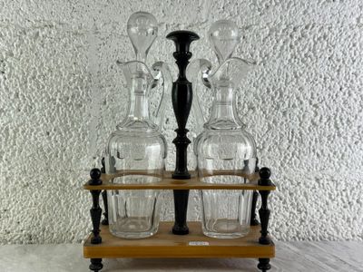 quatre vases en verre posés sur un socle en bois, sur une table