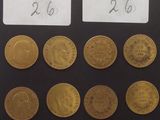 six types différents de pièces d'or sont disposés sur une surface noire