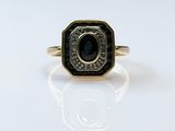 a close up of a gold ring with a black stone in the center