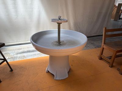 a birdbath that is sitting on a table in a room