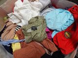 a box full of clothes that is sitting on the floor