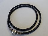 un gros plan sur un bracelet en cuir noir muni d'un fermoir en argent