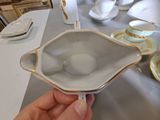 a person holding a white bowl on a table