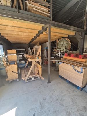 plusieurs pièces de bois sont empilées sur des palettes dans un entrepôt