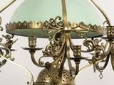 a chandelier with a green glass shade hanging from the ceiling