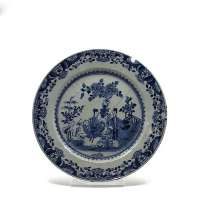 une assiette bleue et blanche sur laquelle sont représentés un homme et une femme