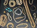 many different types of necklaces and bracelets laid out on a table