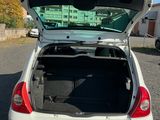 a white car with its trunk open in a parking lot
