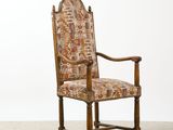 an old wooden chair with a patterned upholstered seat