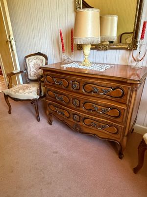 a dresser with a mirror and a chair in the room