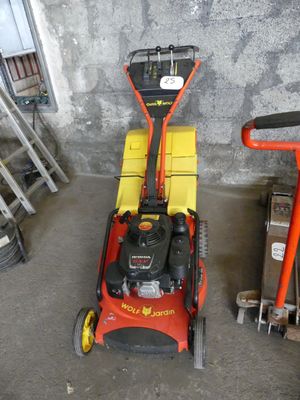 a red and yellow lawn mower sitting in a garage