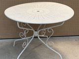a white table with a circular top on the floor