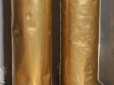two tall gold vases sitting next to each other on the floor