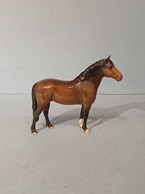 un cheval en jouet posé sur une surface blanche