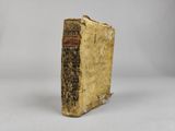 an old book sitting on top of a white surface