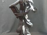 a statue of a woman holding a basket on a table