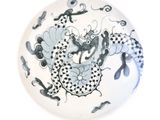 une assiette blanche ornée d'un motif représentant un dragon