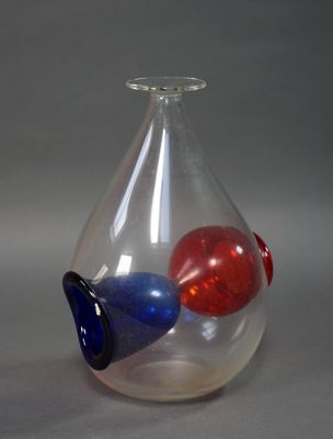 un vase en verre contenant une boule rouge, blanche et bleue