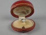 une petite boîte rouge contenant une perle