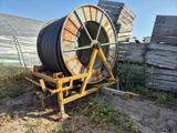 une grande bobine posée sur un chariot dans la terre