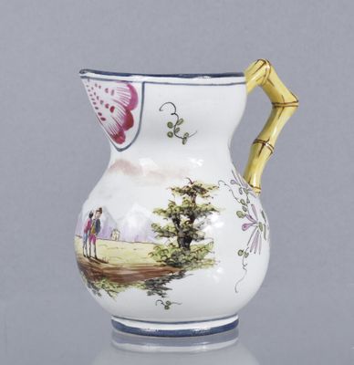 Petite verseuse en faïence émaillée polychrome dans une rése…