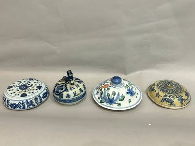 three small blue and white dishes with lids on a white surface