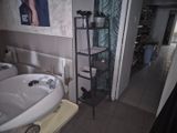 une salle de bains équipée d'un lavabo et d'une étagère