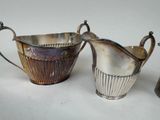 two silver plated pitchers with handles and handles on a white surface