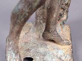 an old bronze statue of a man holding a bird on top of a stone base