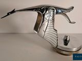 a metal sculpture of a flying bird on a stand