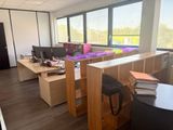 un bureau avec deux ordinateurs et une chaise devant une fenêtre