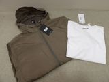 un t-shirt blanc et une veste marron posés sur un lit
