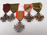 four medals and a cross on a white surface
