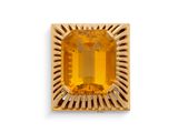 Gros plan sur une bague en or avec une pierre orange