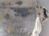 an antique silver tray with a handle and handles on a table