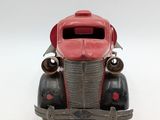 a red toy car that is sitting on a white surface