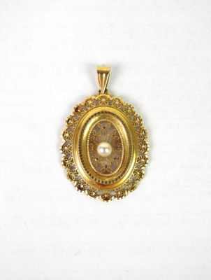 un gros plan d'un pendentif en or serti d'une perle