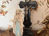 a statue of jesus on a table next to a crucifix