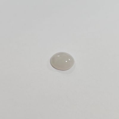 an oval white stone sitting on top of a white surface