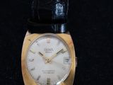 an image of a gold and black watch on a black surface
