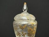 un bocal en verre orné d'un motif de feuilles d'or